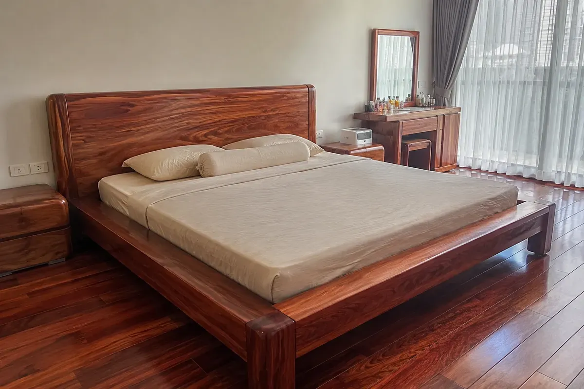 Giường gỗ gõ đỏ với đầu giường lớn tạo điểm nhấn cho phòng ngủ.