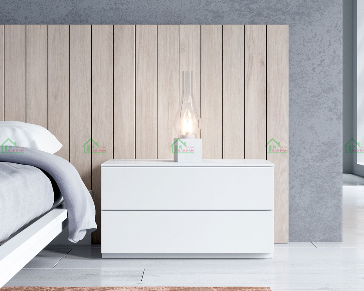 Tủ đầu giường thiết kế màu trắng đồng bộ, tạo sự tương phản với tông màu gỗ tự nhiên của vách đầu giường, đem lại sự hài hòa và tính thẩm mỹ cao.
