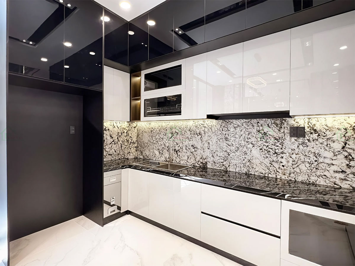 Tủ bếp trên và dưới với cánh acrylic bóng gương màu trắng, tạo cảm giác sáng, rộng rãi