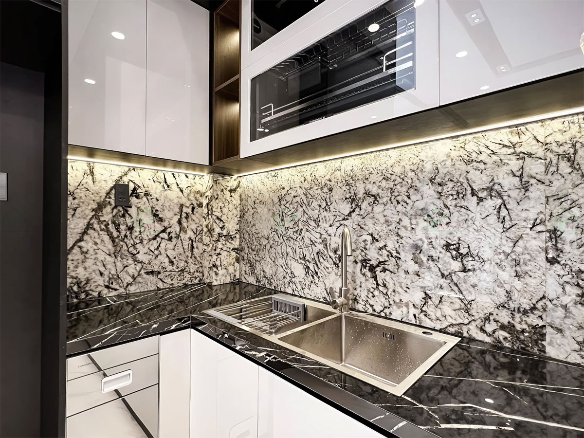 Mặt đá granite đen với vân trắng nổi bật, kết hợp hài hòa với tông đen-trắng chủ đạo.