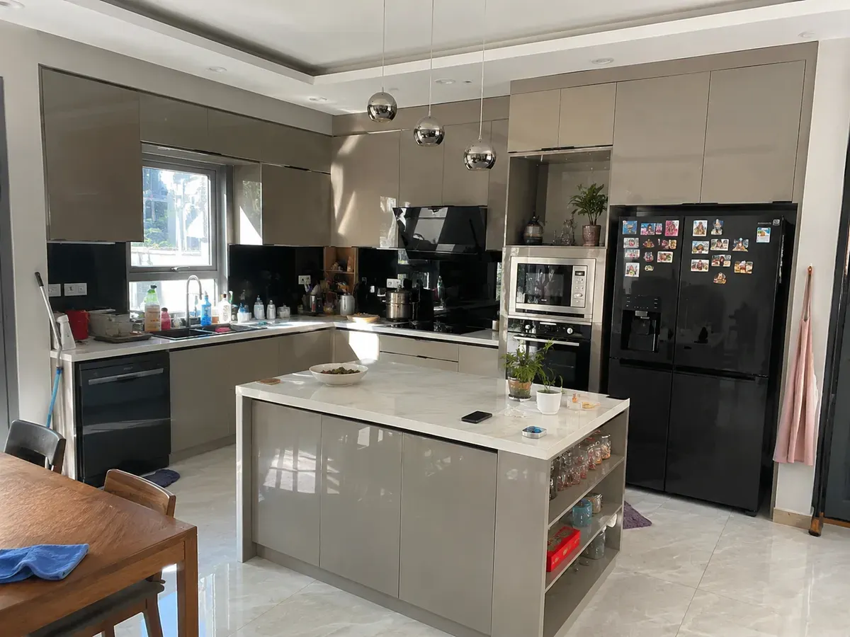 Không gian bếp hiện đại với hệ tủ Acrylic và đảo bếp trung tâm tăng công năng sử dụng.