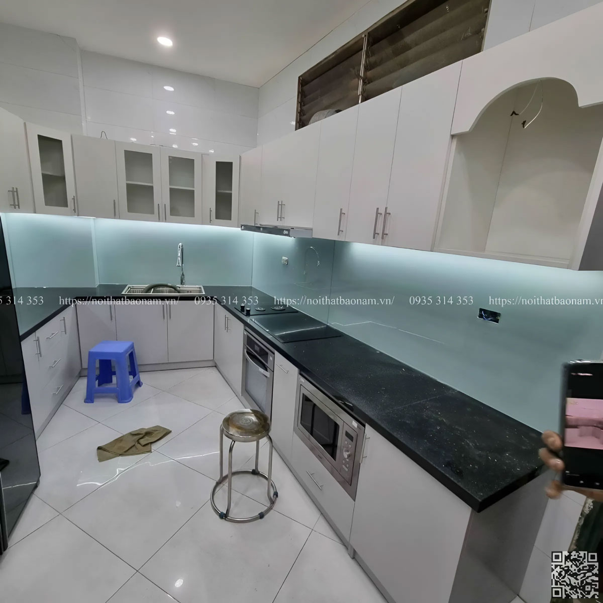 Tủ bếp dưới được thiết kế tối giản với tông màu xám nổi bật, tạo nên sự cân bằng và tương phản với tông trắng.