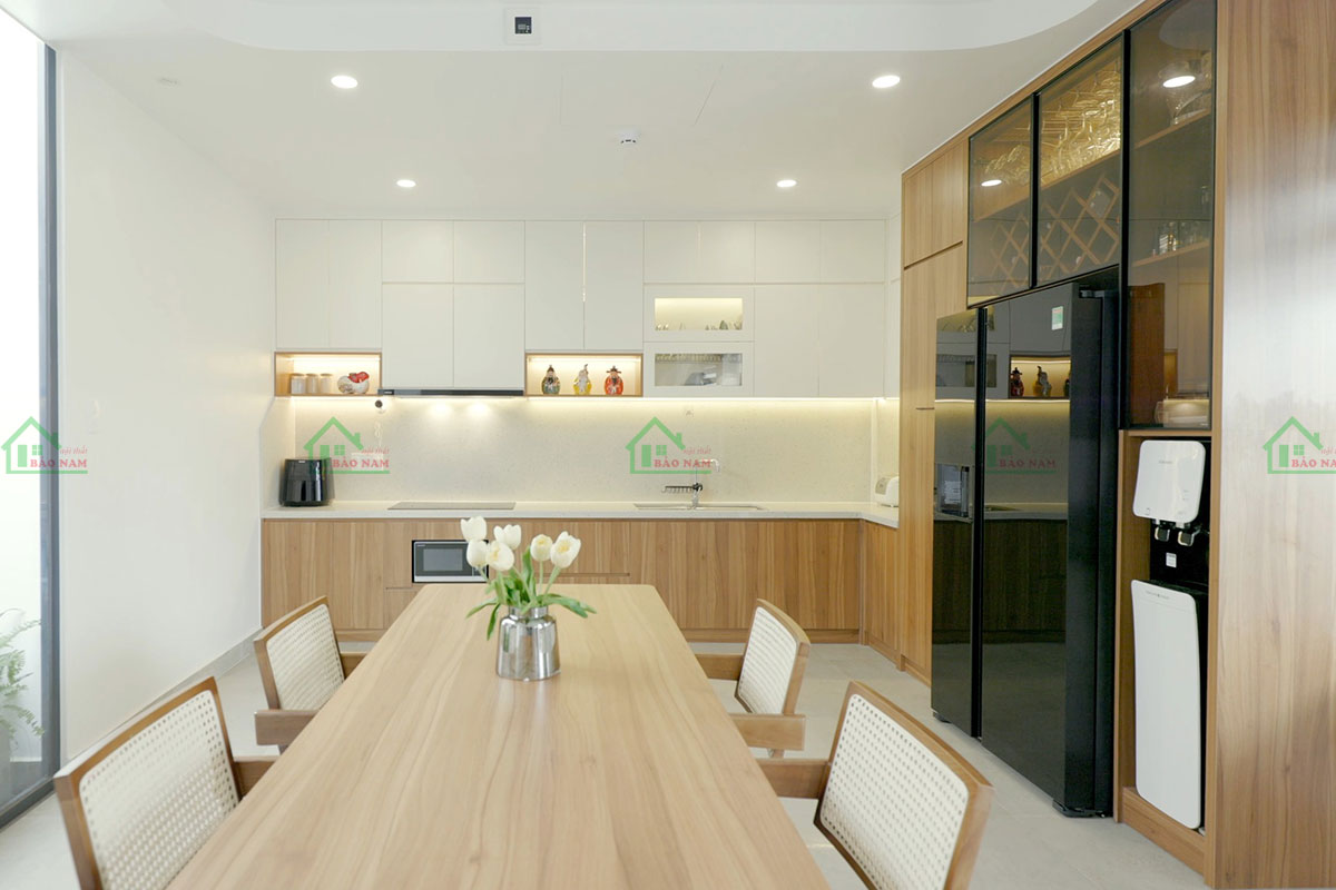 Sự kết hợp giữa màu trắng tinh khôi và vân gỗ ấm áp của bếp trên và dưới tạo nên sự hài hòa và hiện đại.